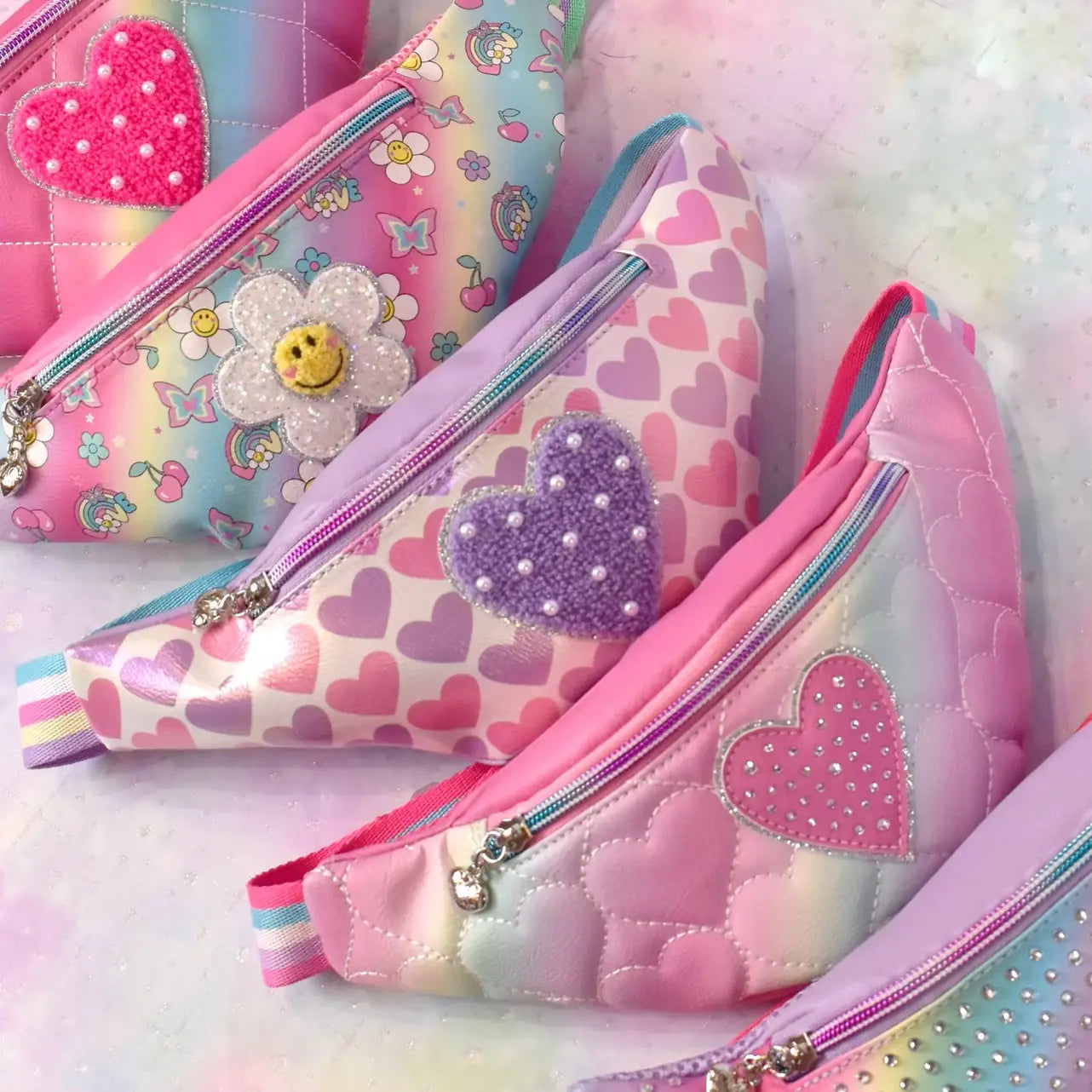 Colorful kids fanny packs with heart and flower designs in pink and pastel shades, perfect for stylish accessories.