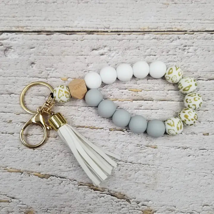 Porte-clés avec bracelet en perles de bois et pompons léopard